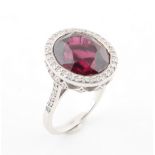 A good rubellite & diamond cluster ring, the large oval cut rubellite weighing approximately 11.83