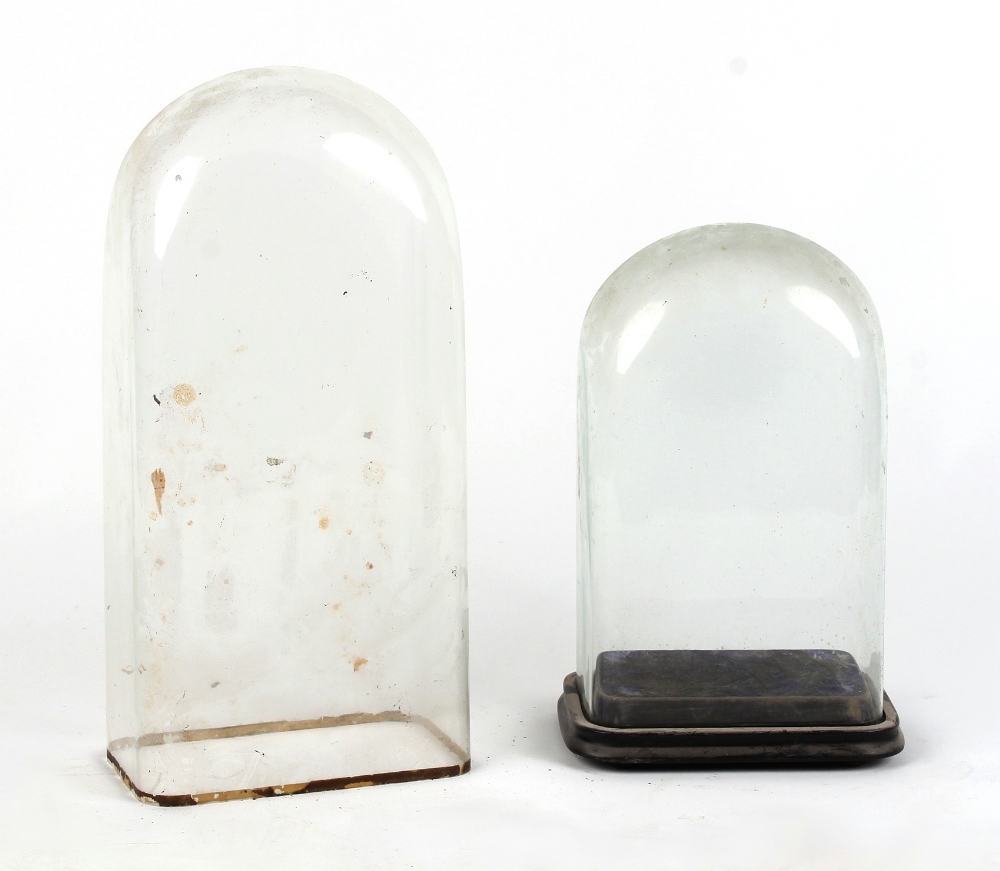 Two late 19th / early 20th century glass clock domes, the taller 20.5ins. (52cms.) high (2).