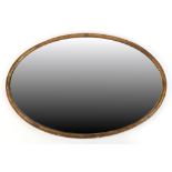 Property of a lady - an early 20th century gilt composition oval framed wall mirror, 37.5 by