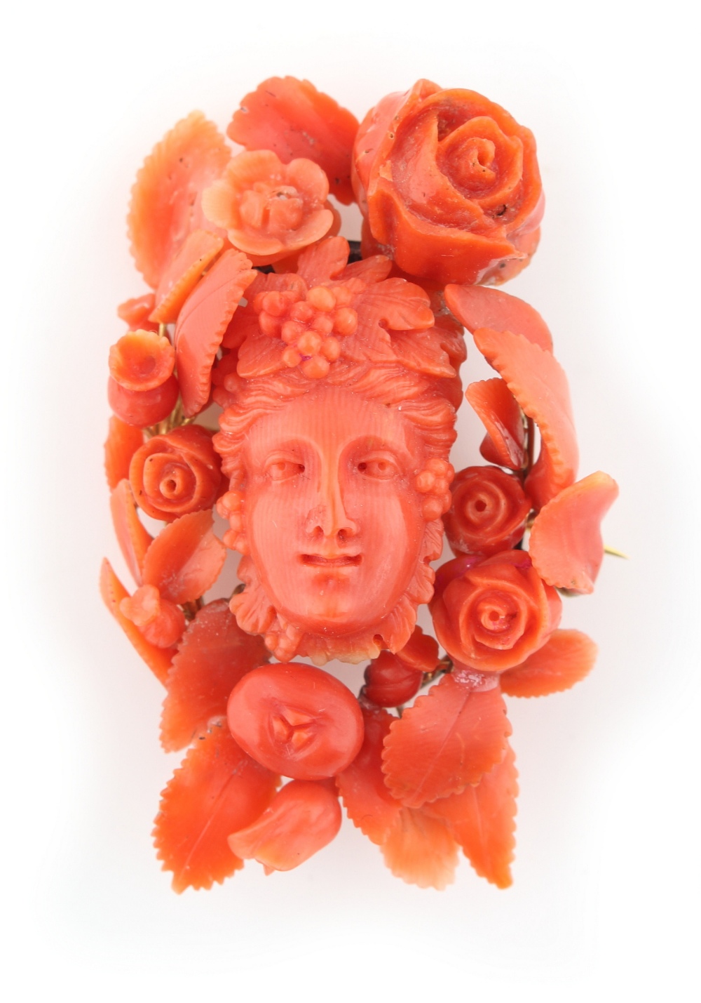 A large late 19th / early 20th century carved coral brooch in the form of a mask within a border