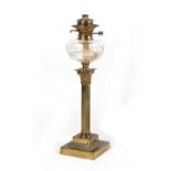 An Edwardian brass Corinthian column paraffin oil lamp, with glass reservoir, 21.25ins. (54cms.)