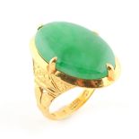 A Chinese high carat gold & jadeite ring, the large oval cabochon apple green jadeite measuring