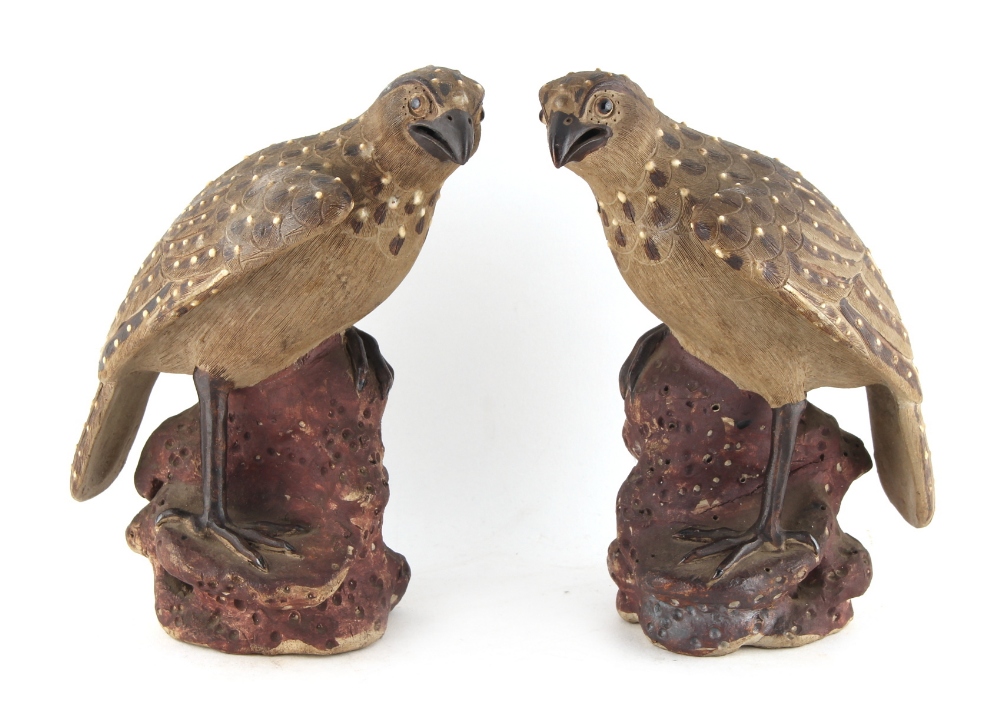 Property of a lady - a pair of early 20th century Japanese pottery models of perched hawks,