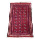 Property of a deceased estate - an Afghan rug with three rows of guls on a red ground, 57 by