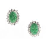 A pair of unmarked white gold carved apple green jadeite & diamond oval cluster earrings, with