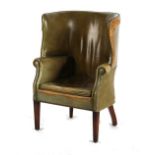 Property of a gentleman - a George III style green leather upholstered wing armchair, damages to