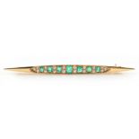 An unmarked high carat yellow gold emerald & diamond stock pin, the seven octagonal cut emeralds