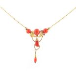 An 18ct yellow gold & coral pendant necklace, with carved coral hand, 17.3ins. (44cms.) long.