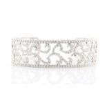 An 18ct white gold diamond openwork bangle, set with approximately 480 round brilliant cut