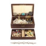 A brown leather jewellery box containing assorted costume jewellery.