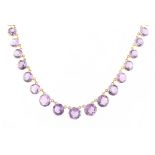 A 9ct yellow gold amethyst riviere necklace, with thirty-eight round cut amethysts, 15.5ins. (39.
