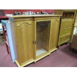 An Oak Breakfronted Bookcase, with a central glazed door, arched flanking cupboard doors, stepped