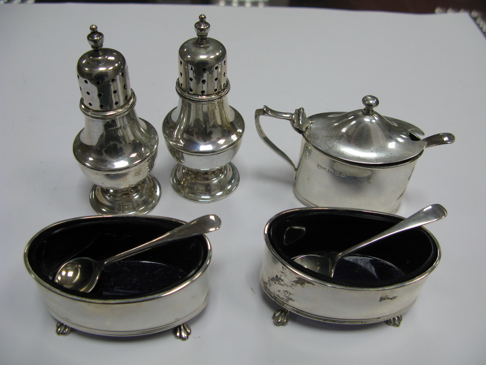 A Hallmarked Silver Five Piece Cruet Set, of plain design; together with a set of three associated