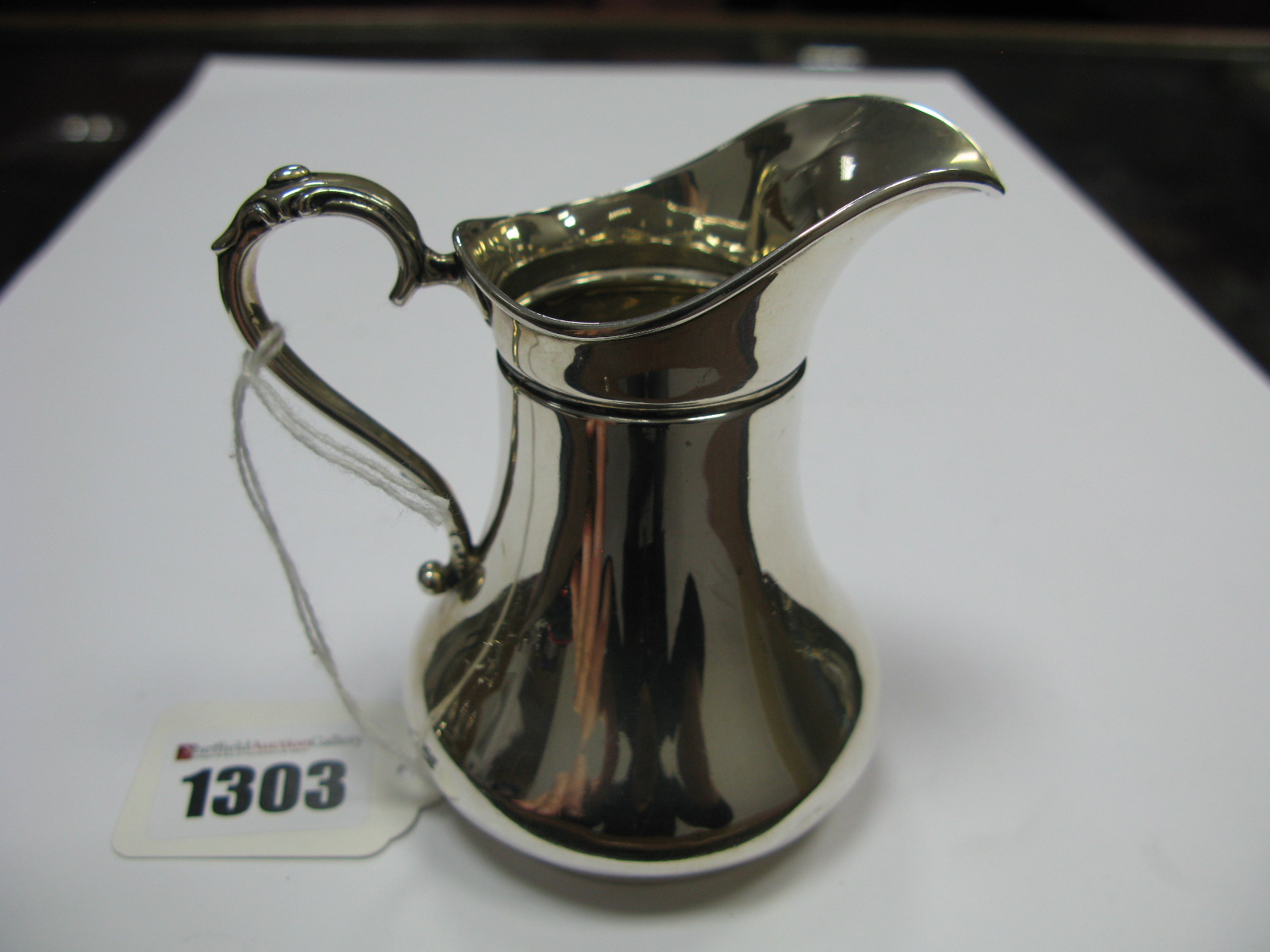 A Hallmarked Silver Jug, of plain baluster form, on rim base.