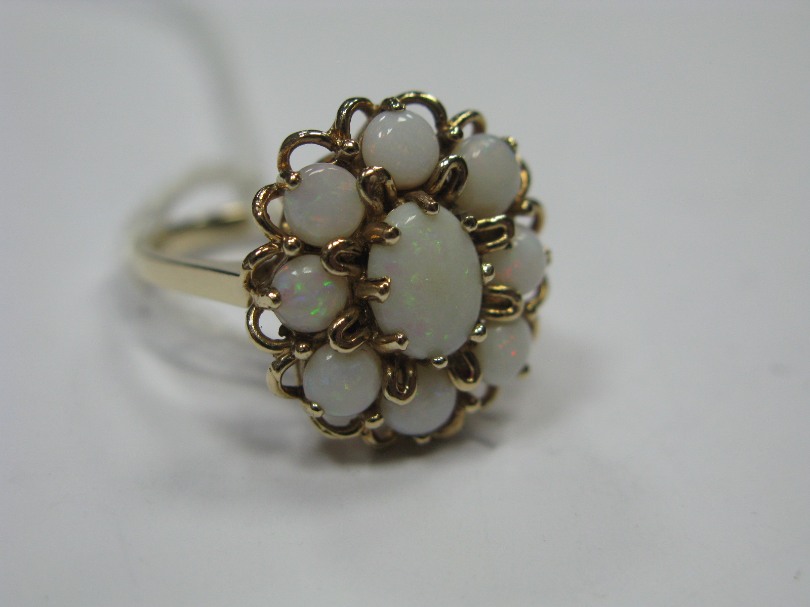 A 9ct Gold Opal Set Cluster Ring, of openwork design.