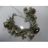 A Curb Link Charm Bracelet, to heart shape padlock clasp, suspending numerous novelty charm