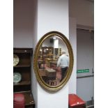 An Early XX Century Gilt Framed Oval Bevelled Wall Mirror.