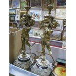 A Pair of Cast Brass Cherubic Table Lamp Bases, mounted on foliate squared cast base, height 62cm (