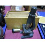 A Brass and Cast Metal Microscope, and lens, in a wooden case.