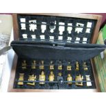 A Carved Chess Set, the pieces as Chinese figures, with chess board fitted case.