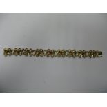 A Floral Design Stone Set Bracelet, of openwork design, with claw set highlights, to snap clasp