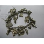 A Curb Link Charm Bracelet, suspending numerous novelty charm pendants.