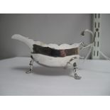 A Hallmarked Silver Sauce Boat, (marks indistinct) with wavy cut edge and flying scroll handle,