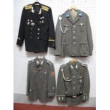 Four Post War Eastern European Military Tunics, one with trousers.