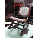 An Unusual Early XX Century Folding Rocking Chair, with rose carved cresting.