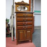 An Early XX Century Walnut Music Cabinet, with mirrored back, four pull out drawers over twin