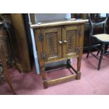 A XX Century Oak Cabinet, with twin panelled doors, on turned and block supports.
