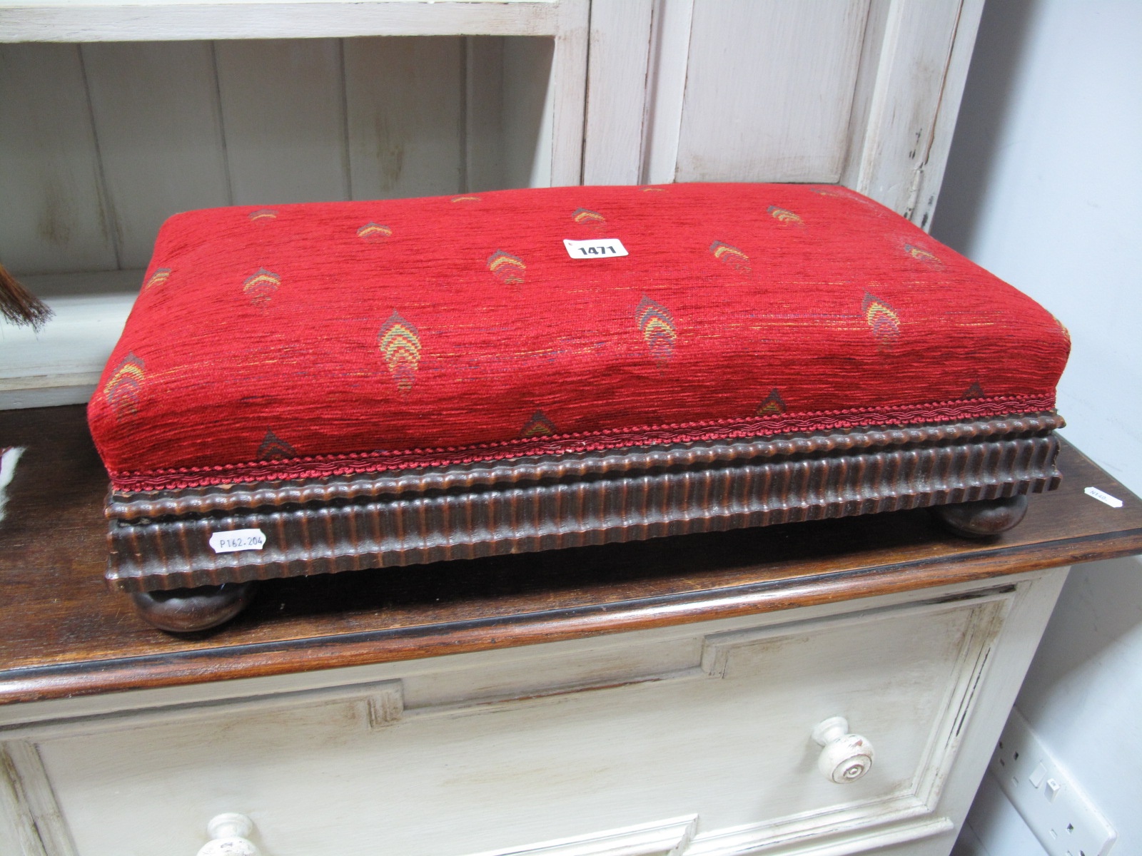 A 1920's Footstool, with rectangular upholstered top, knulled decoration, on bun feet.