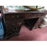 A Mahogany Pedestal Desk, with a cross banded top, green leather sciver, twin pedestals on bracket