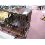 An Edwardian Mahogany Revolving Bookcase, with inlaid top, rail supports, open shelves. (damaged)