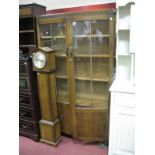 A 1930's Oak Book Cabinet, with glazed and panelled doors,concealing adjustable shelves on twin ball