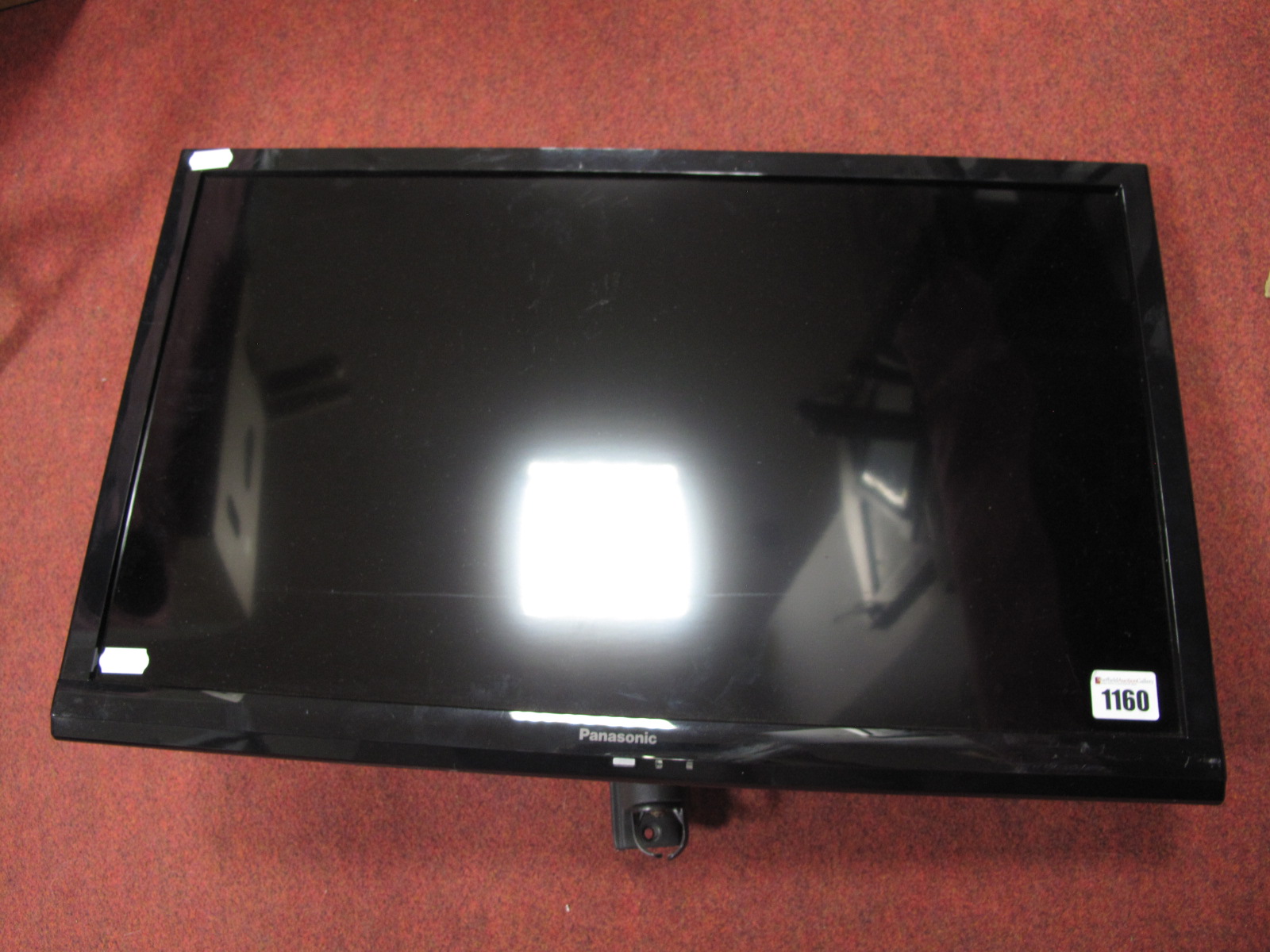 A Panasonic 24" LCD TV, model TX-24ASS10B - fitted for wall mounting, no stand.