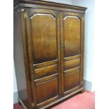 A Titchmarsh & Goodwin Oak Wardrobe, with stepped pediment, twin panelled doors, on bracket feet,