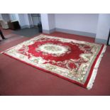 A Chinese Wool Tassled Carpet, with cream central motif, all-over rose and scroll decoration on