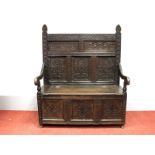 A XVII Century and Later Joined Oak Box Settle, with a three carved panel back, shaped arms and