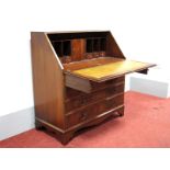 A Reprodux Mahogany Bureau, with fall front, fitted interior over two small and three long