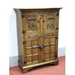 An Oak Drinks Cabinet, carved with tavern scene interiors to upper doors, concealing serpentine