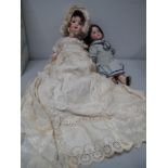 Two Porcelain Headed Dolls, one with head stamped 'Germany', fixed eyes, open mouth with teeth,