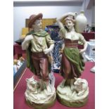 A Pair of Royal Dux Pottery Figures of Peasants, she carrying an urn, a sheep by her feet, he with a