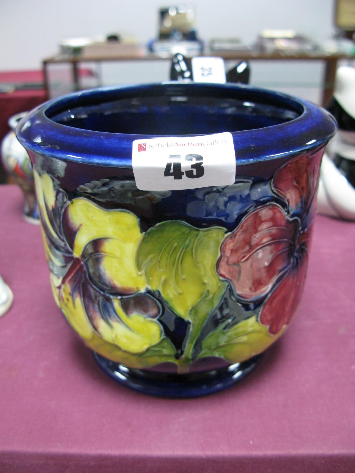 A Moorcroft Pottery Planter, painted in the Hibiscus pattern against a blue ground, impressed and