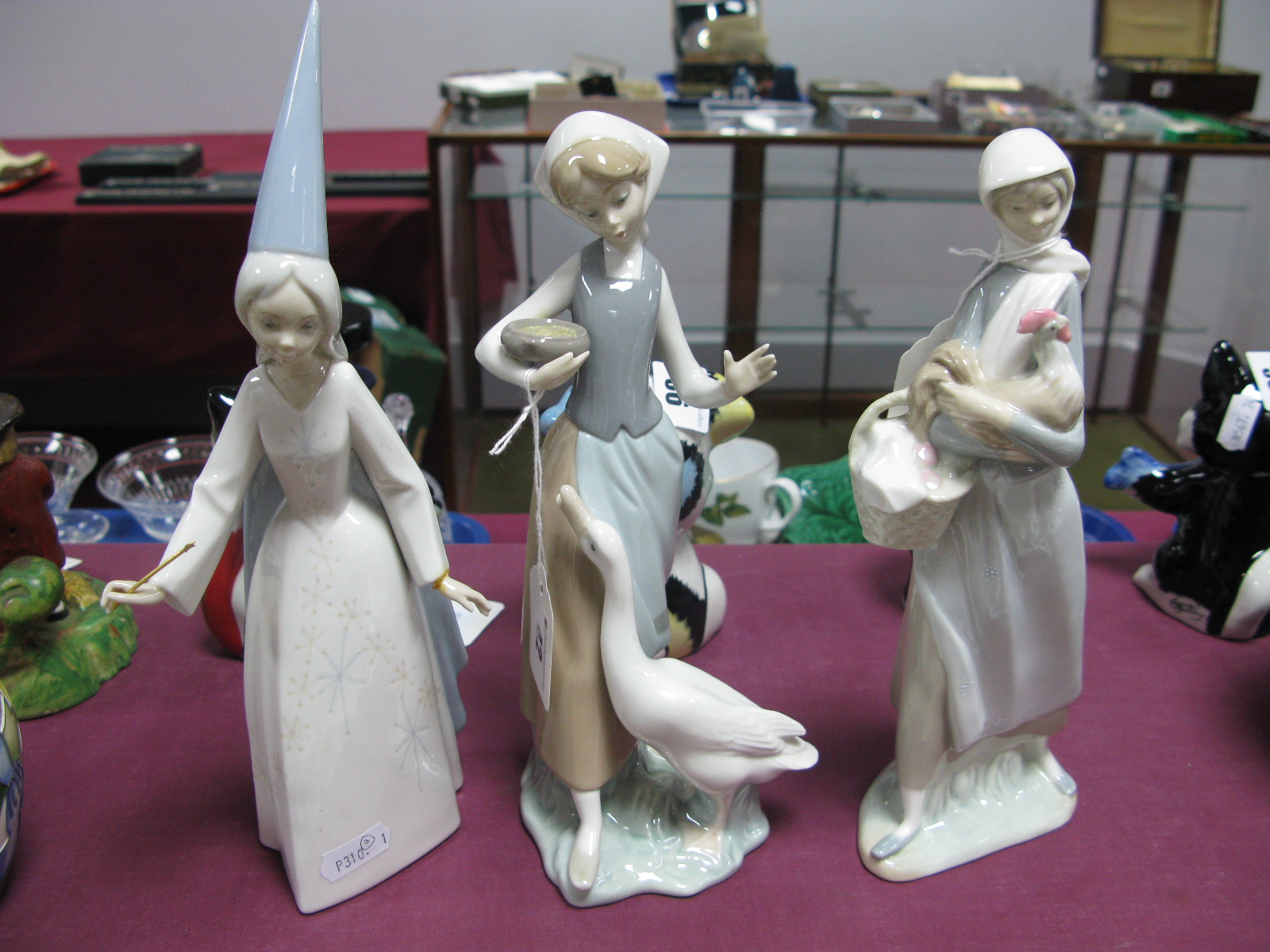 Lladro Pottery Lady Holding Hen, C-15F; Geese Feeder, H-31M and (damaged) Magician, O-270. (3)