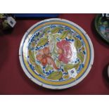 An Early XX Century Tin Glazed Pottery Dish, painted with red and orange flowers within a blue and