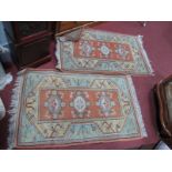 A Pair of Middle Eastern Wool Tassled Rugs, each with three central motifs on orange panel within