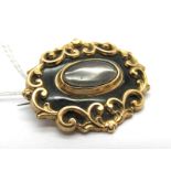 A XIX Century Mourning Brooch, of shaped oval form with central oval glazed locket panel.