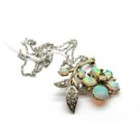 An Opal and Diamond Set Pendant, of flowerhead and leaf spray design, claw set with graduated oval