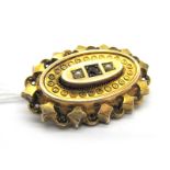 A Victorian Oval Locket Back Brooch, inset to the centre, within textured and pierced border, with